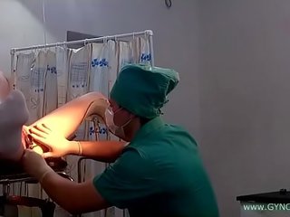 Un joven damisela en blanca calcetines en un ginecólogo silla